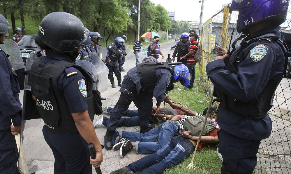 Honduras police agents detain campesino leaders in the Aguan Valley at a protest in the capital